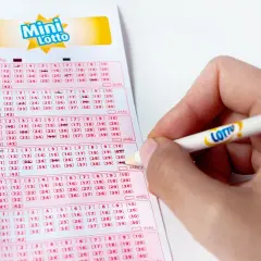 Ręka zaznacza liczby na kuponie Mini Lotto. To kaskada zasady, gdzie każda kolejna linijka to szansa na wygraną.