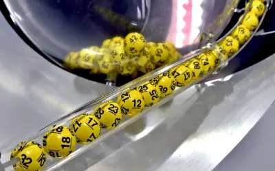 Żółte kulki z numerami, jak w grze multi multi zasady, toczą się w przezroczystej tubie.