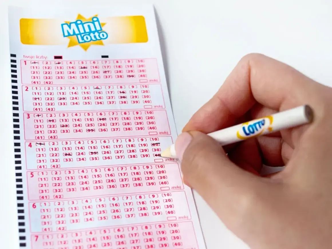 Ręka zaznacza liczby na kuponie Mini Lotto. To kaskada zasady, gdzie każda kolejna linijka to szansa na wygraną.